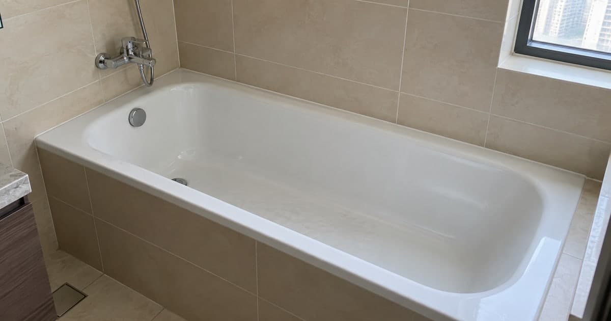 Full-size bathtub in a tiled bathroom alcove